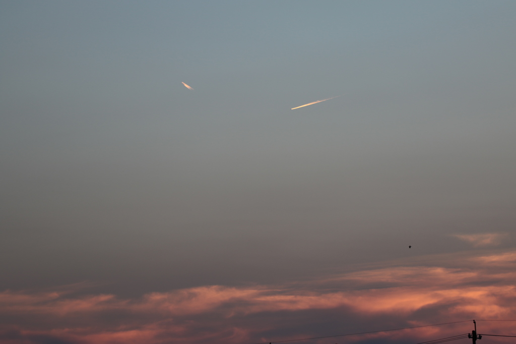 夕日に照らされる飛行機雲