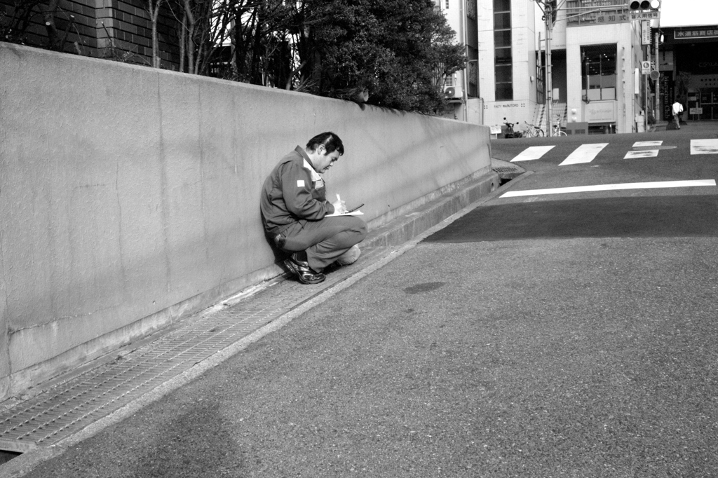 道端に座り込み朝から働く者の姿