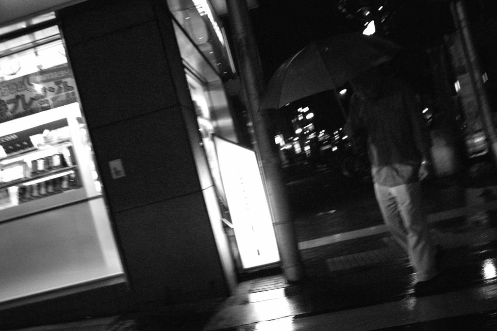 傘を差し歩く老人