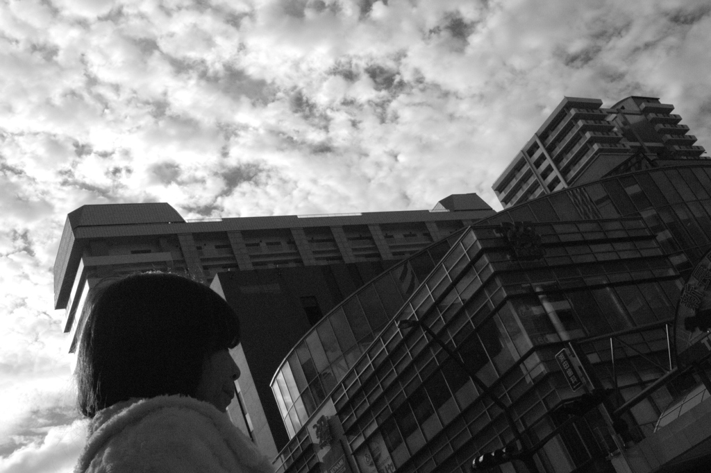 雲空とビルと女性