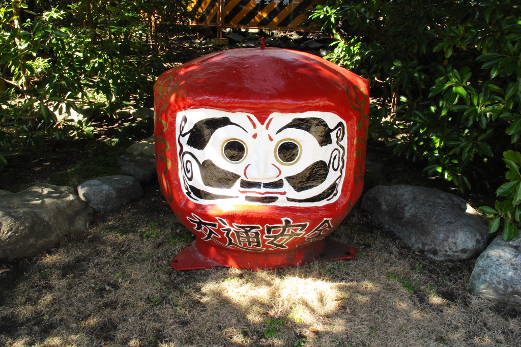 A Daruma doll under trees