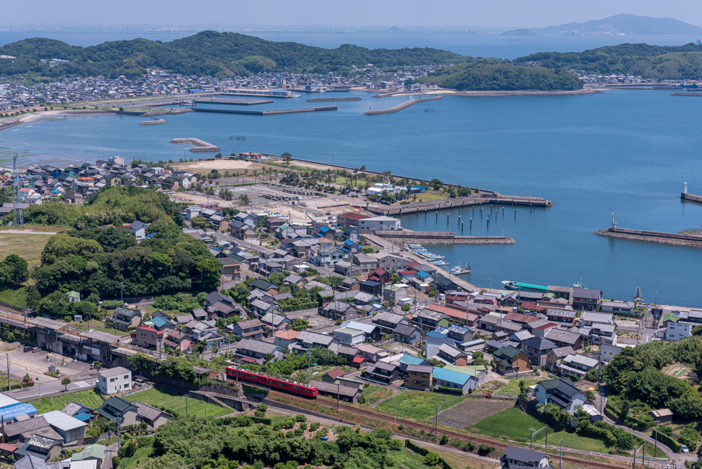 海辺の街をゆく赤い電車