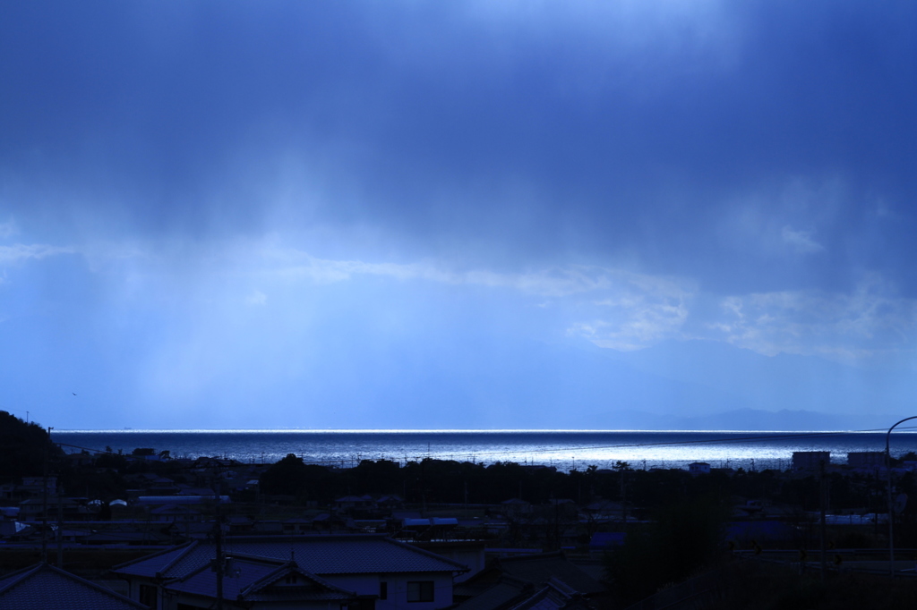 水平線を照らす光と降り注ぐ雲