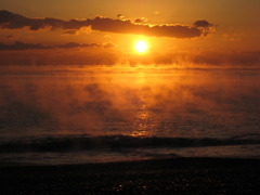 蒸気の上がる海から昇る太陽