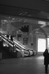 通話中女子とエスカレーター