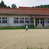 白い木造校舎とテニスで遊ぶ児童