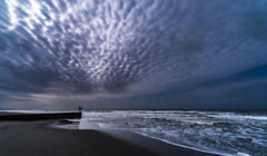 雨上がりの海で波を待つ