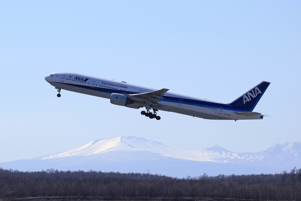 残雪の樽前をバックにANAの離陸