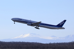 残雪の樽前をバックにANAの離陸