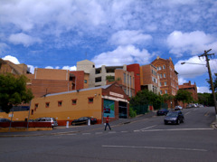 Blue cloudy sky, bricks, car, and a man
