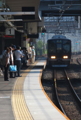 朝日を浴びて列車を待つ