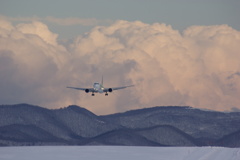 雪雲と山と飛行機、夕暮れ間近。