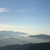 重なる山の向こうにうっすらと・・
