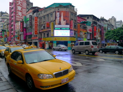 黄色のタクシーとにぎやかな看板