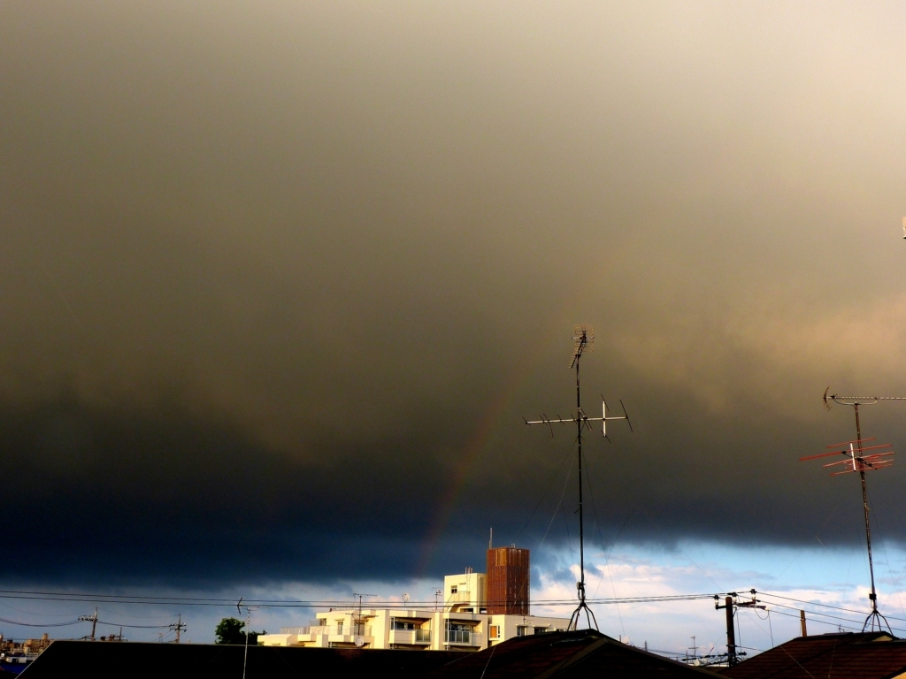 虹を呑み込む黄砂のような雨雲