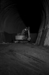 トンネルの先端で孤独に掘り続けるある重機