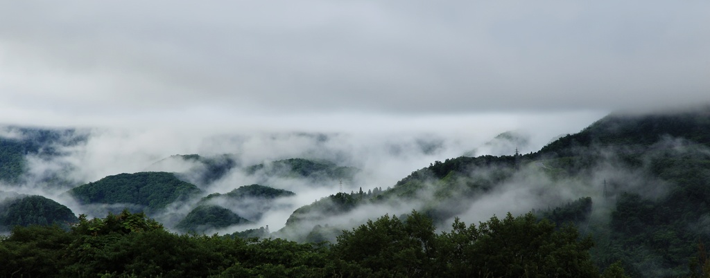 煙る山