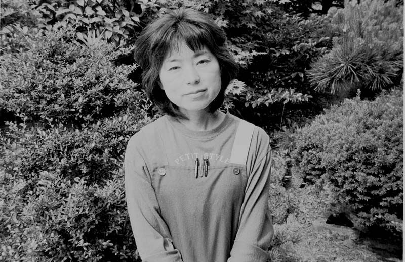 自宅の玄関先に立つ洋子