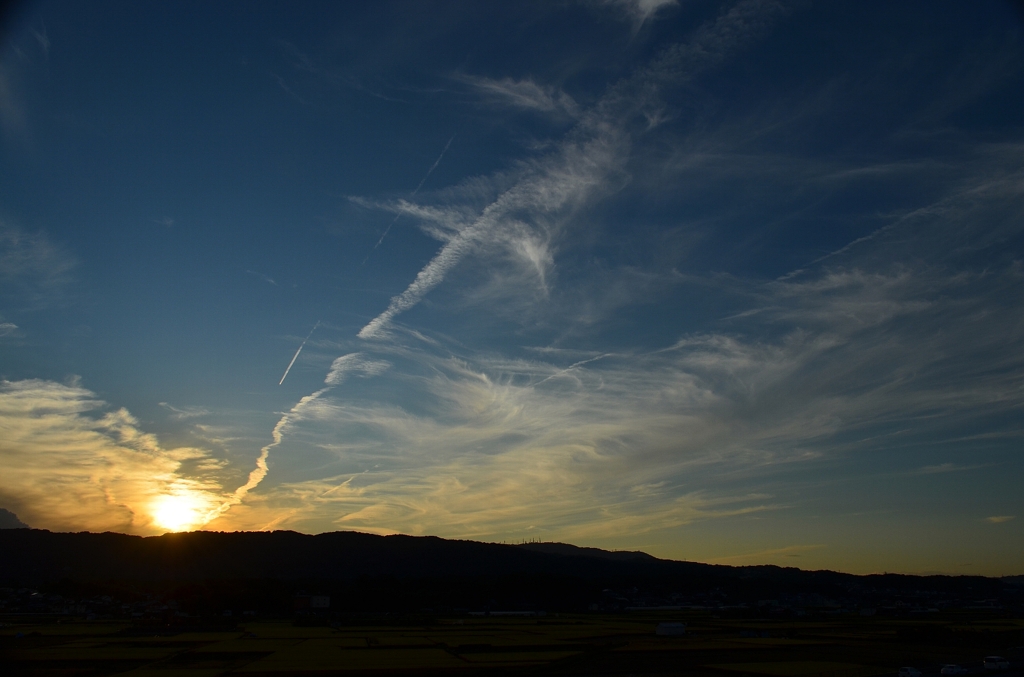 日没寸前の飛行機雲と筋雲