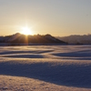 田んぼの向こうに沈む冬の夕日