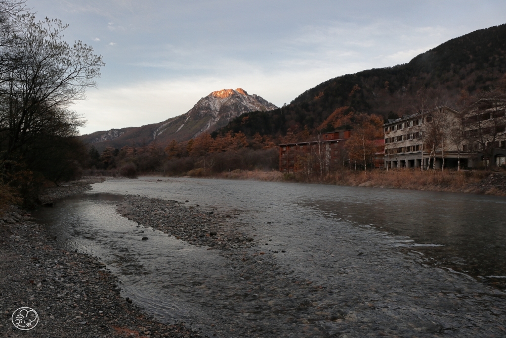 山頂を朝日に照らされる焼岳