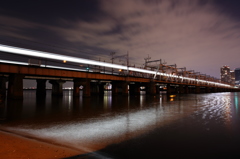 阪急電車の光跡が川面を照らす