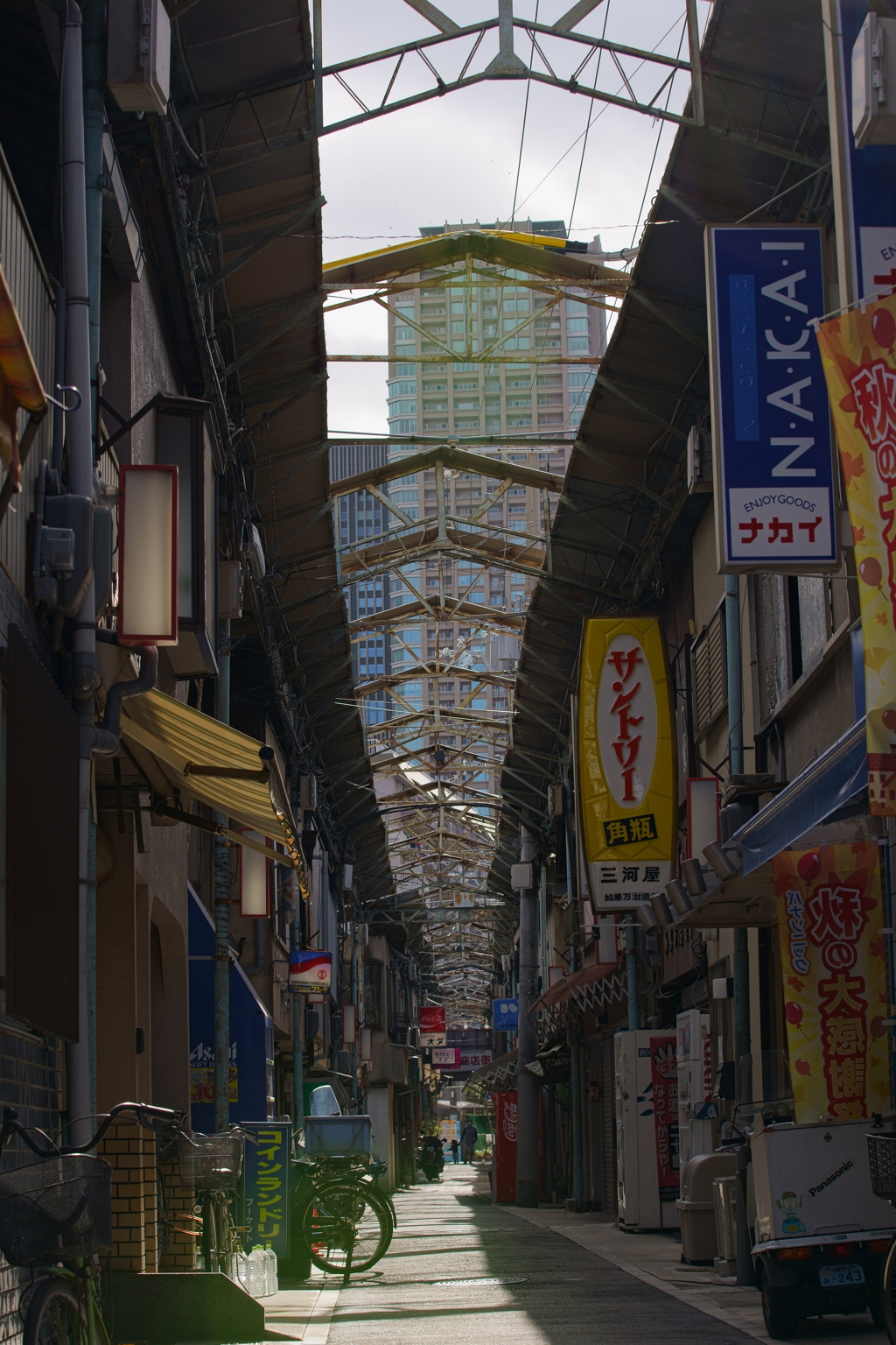昭和の香りのする商店街と高層ビルの見える風景