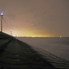 海岸に並ぶ風車の列と新潟の街灯り