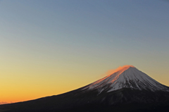朝焼けに照らされる富士の雪煙