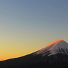 朝焼けに照らされる富士の雪煙