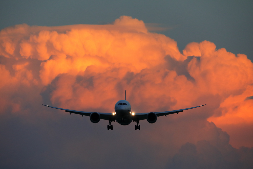 オレンジに染まる大阪上空の巨大な積乱雲を超えて