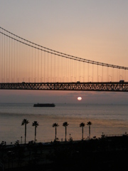 橋と夕日とコンテナ船