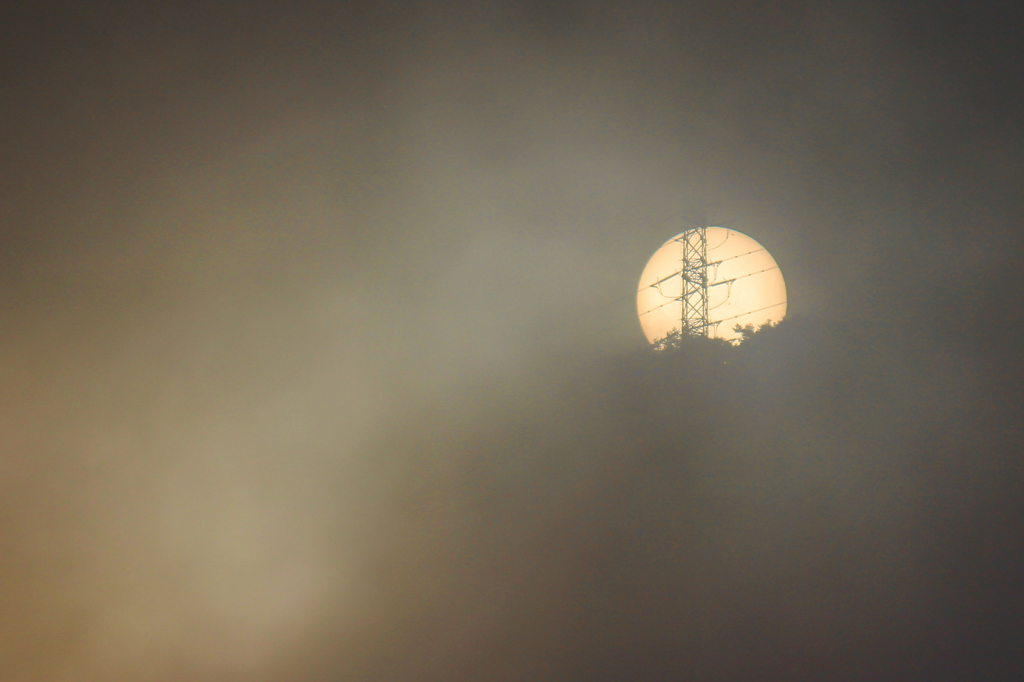 霧の朝日と鉄塔