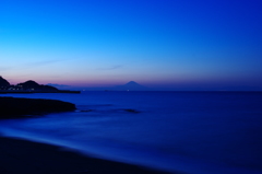 夕暮れに海の向こうに富士山が佇む