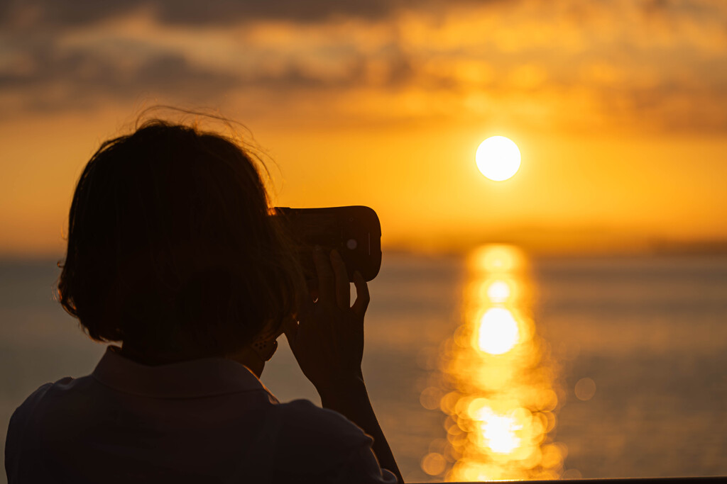 夕陽を撮る女性