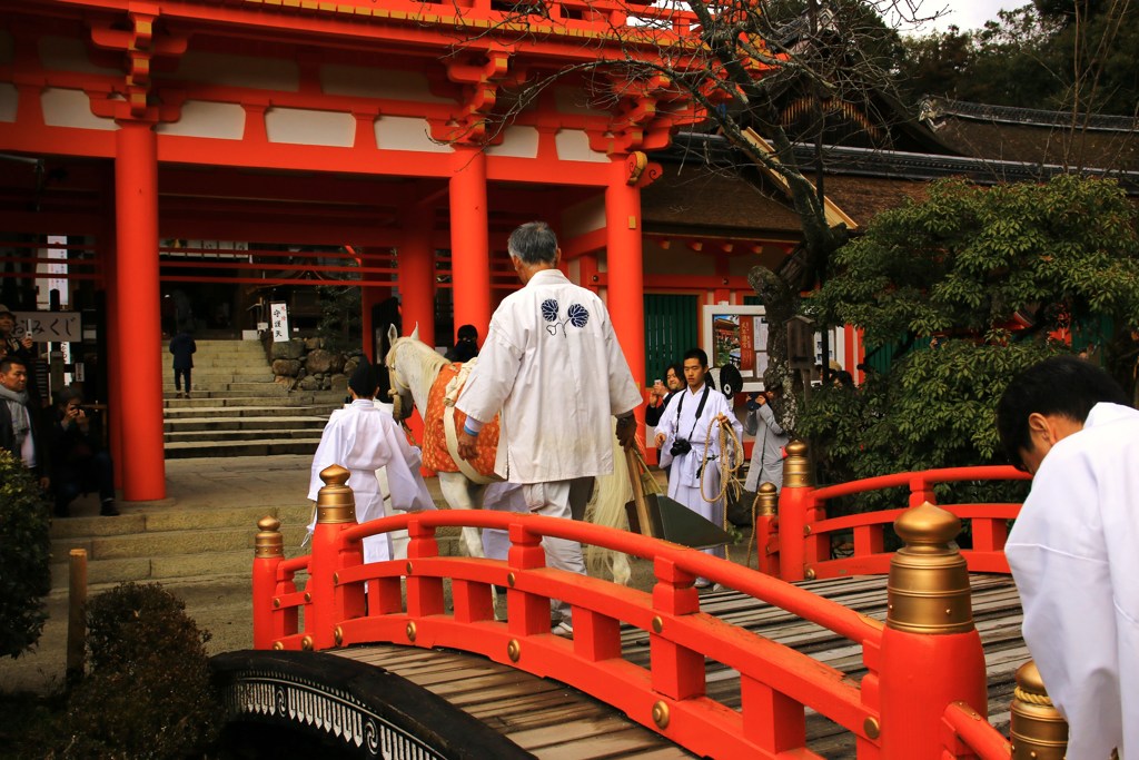 太鼓橋を渡り本殿へ参拝する白馬