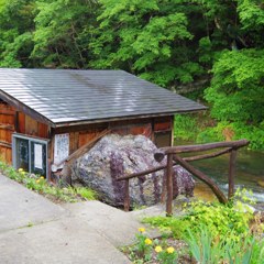 ONSEN hut with sacred rock along river