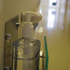 Hand sterilizing gel bottle on wall
