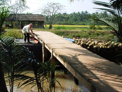 ココ椰子を積むボートが橋をくぐる