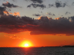 雲と海の間に太陽沈む