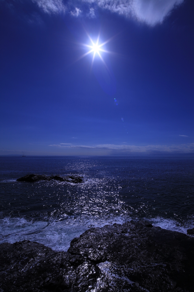 岩礁を照らす太陽、そして青い海と空