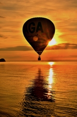 熱気球朝日に向かって飛ぶ