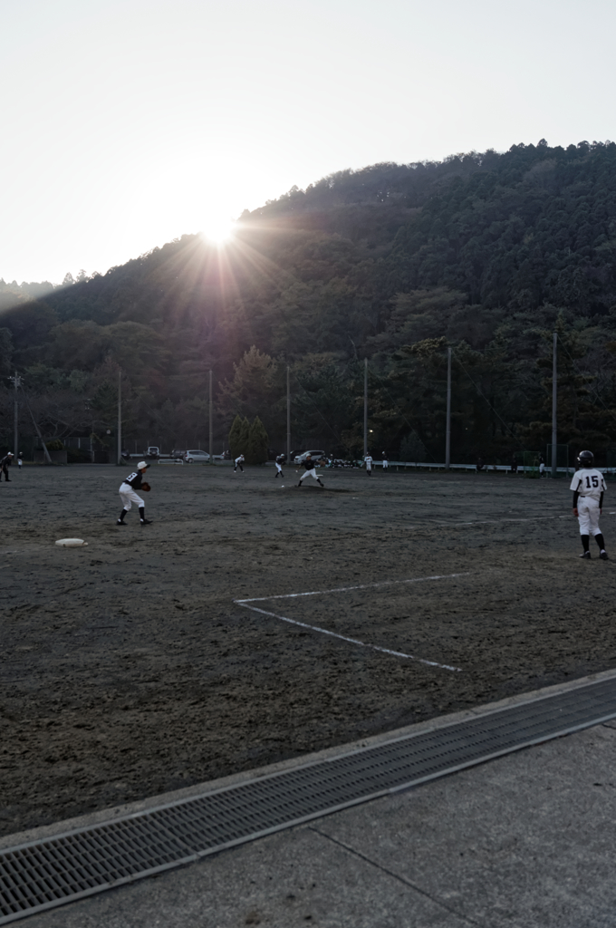夕日と野球少年たち