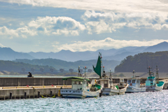 秋の光を釣る少年と海
