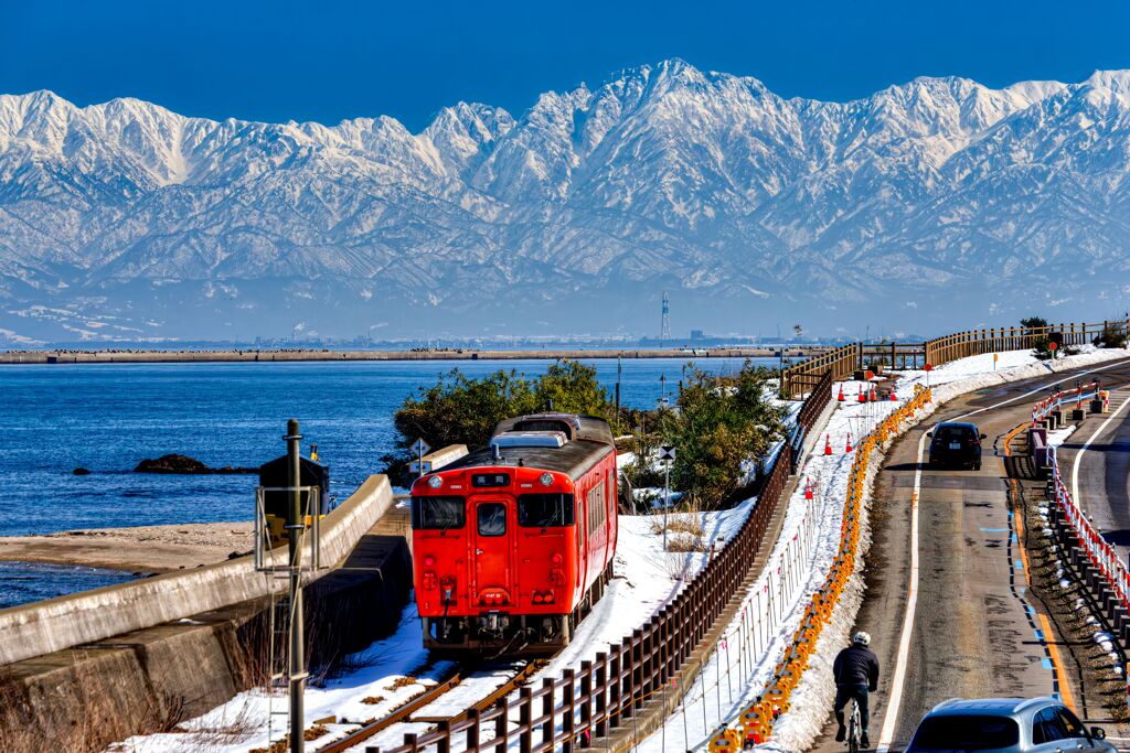 氷見線と海越しの立山連峰