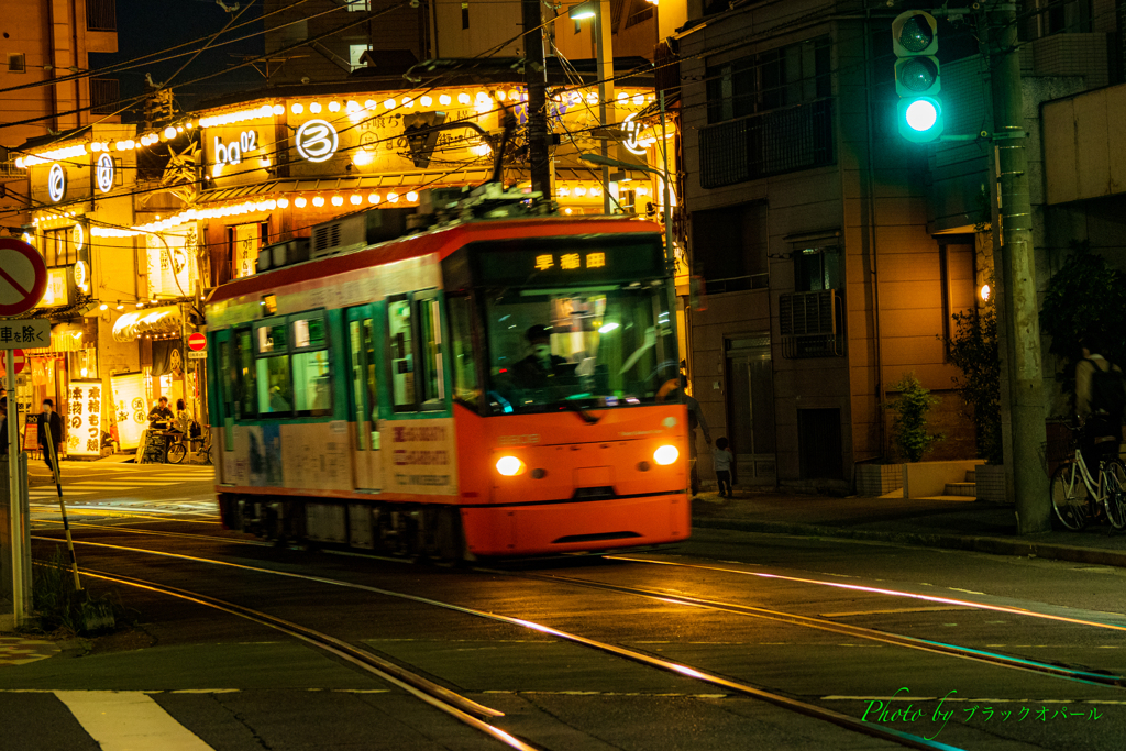 夜の街角を行く都電..