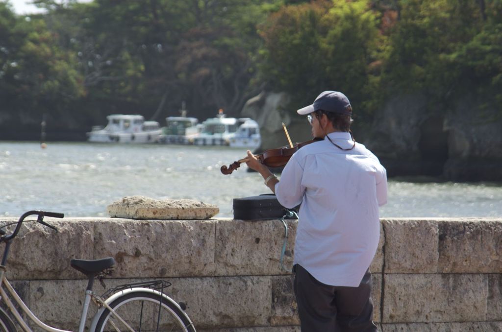 松島の海に向かってヴァイオリンを弾く男2