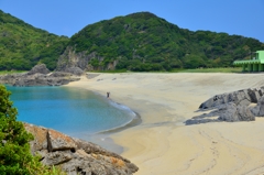 砂浜に斜視を取る娘