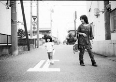 走る娘とそれを見る妻