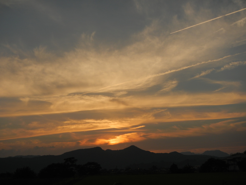 秋の夕空と飛行機雲